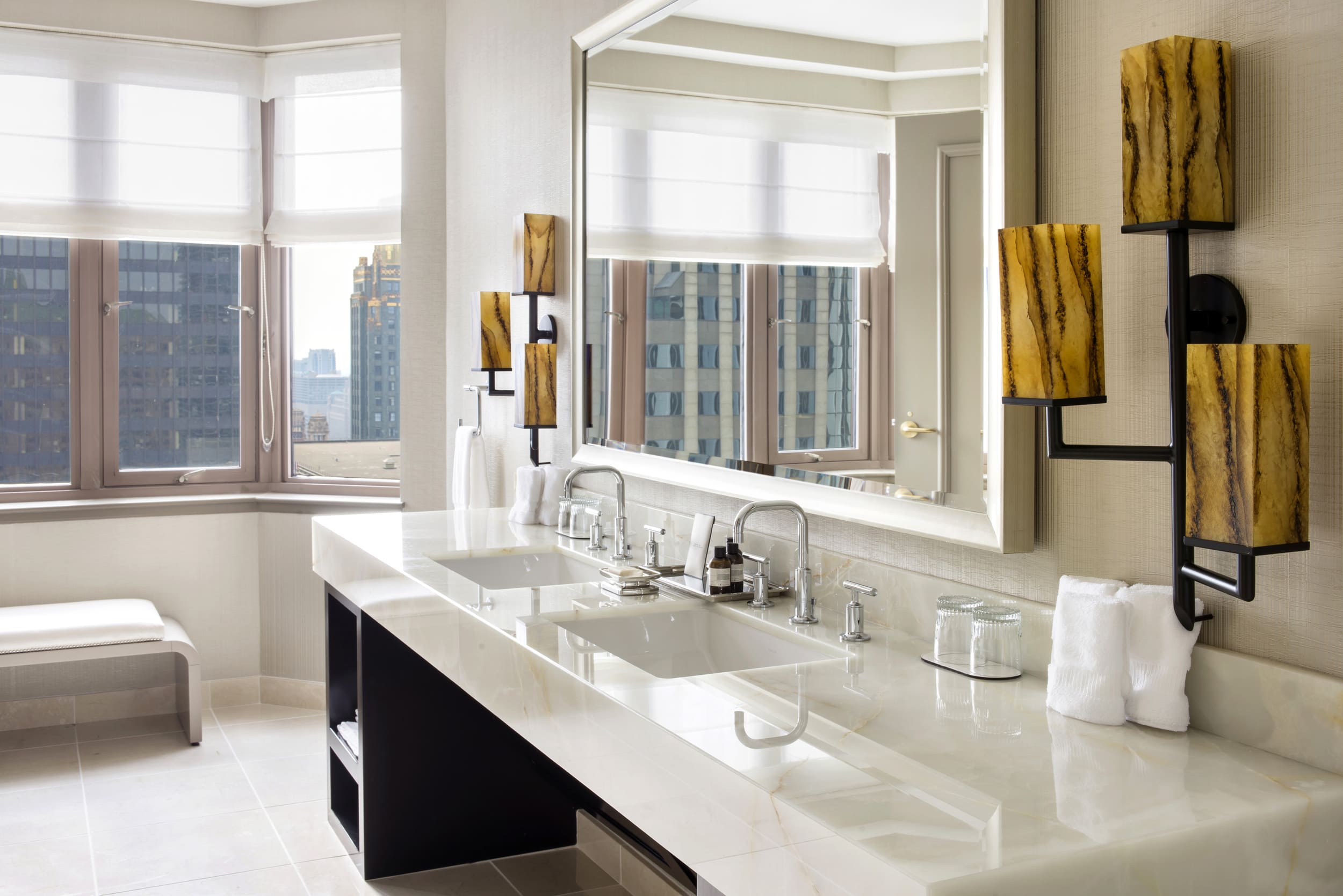 bathroom counter with two sinks and view of the city