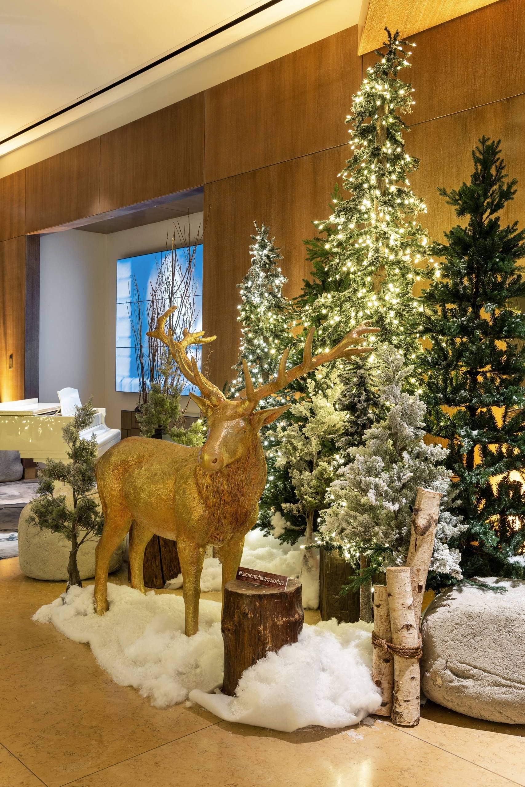 Christmas trees set up with fake snow and wooden deer