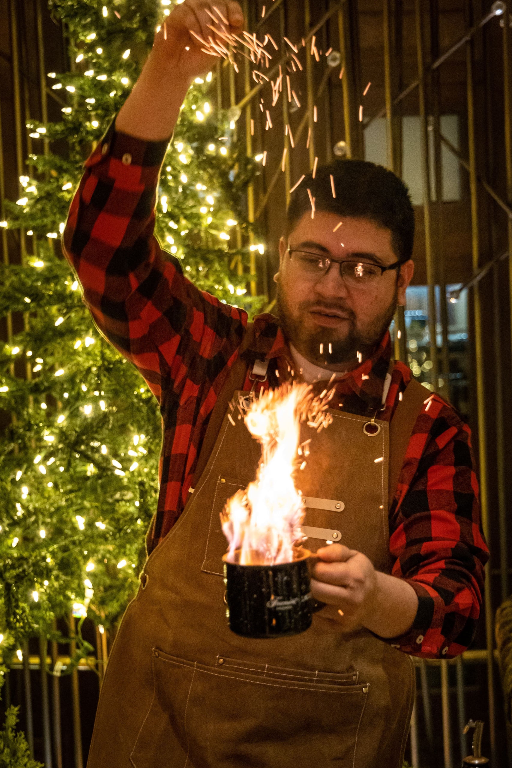 a man in an apron holding a mug of fire